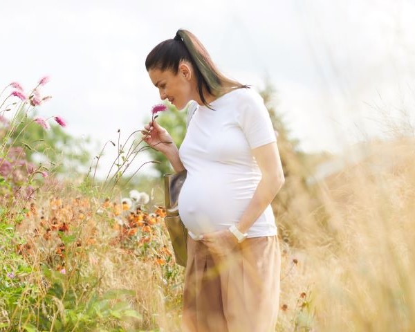 Woman smelling flower in a field.