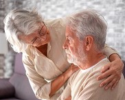 An elderly man sad with his wife comforting him