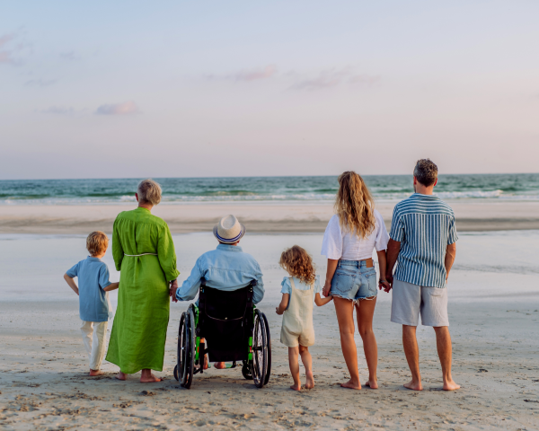 Multi-generational family standing together on a beach