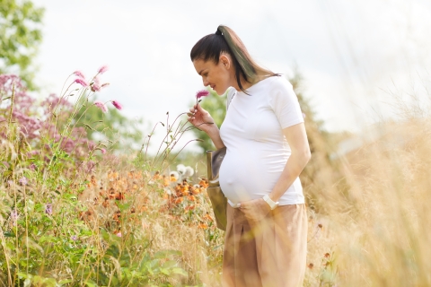 Woman smelling a flower in a field.