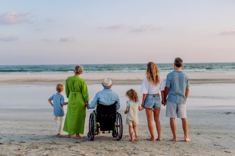 Multi-generational family standing together on a beach