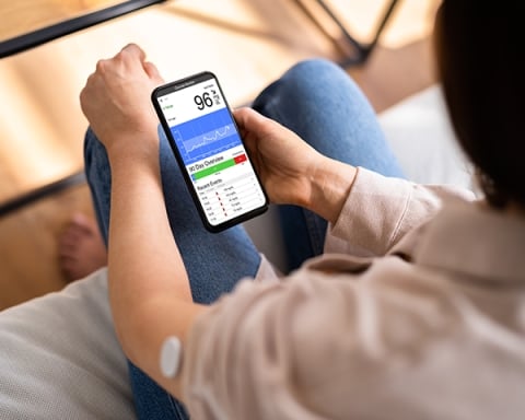 person with diabetes checking app on mobile phone